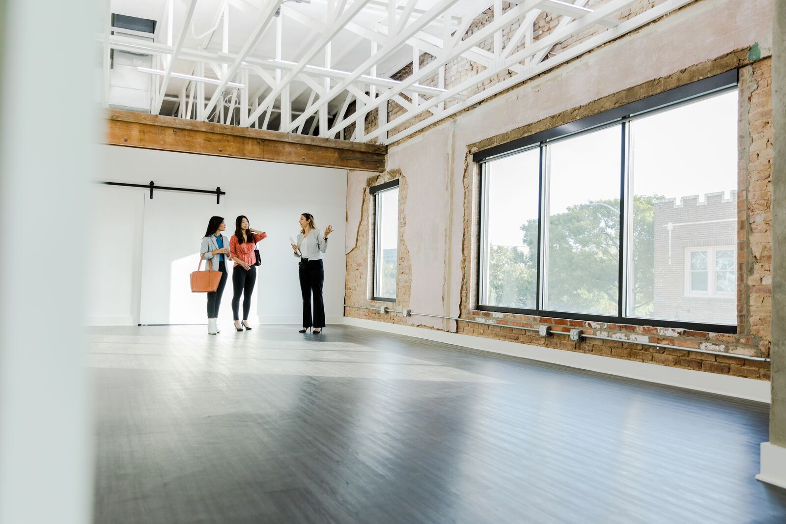 A real estate agent showing a commercial office space to business owners